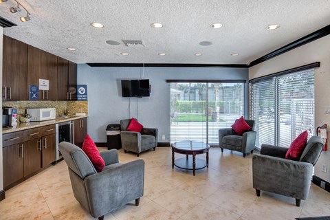 a living room with couches and chairs and a kitchen